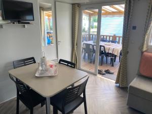 a dining room with a table and chairs and a dining room with a deck at Résidence les dunes de Contis in Saint-Julien-en-Born