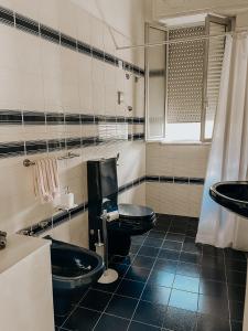 bagno con 2 servizi igienici neri e lavandino di Maison Li Signuri a Maglie