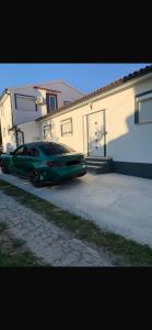 un coche verde estacionado frente a una casa en Apartments Stinjan, en Pula
