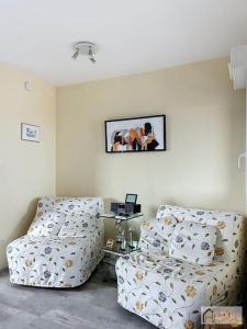 a living room with a couch and a table at Le Petit Golf - Balcon, Plage à 50m in Bray-Dunes