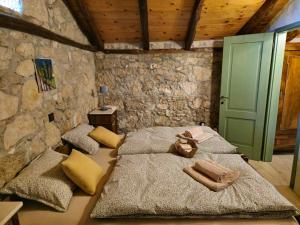 two beds in a room with a stone wall at Kuća za odmor Ameli in Mošćenička Draga