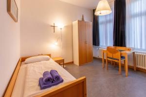 ボルクムにあるGaestehaus-St-Josef-4のベッドルーム1室(ベッド1台、テーブル、椅子付)