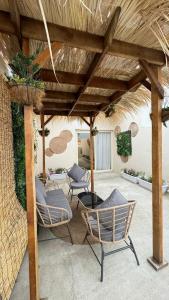 un patio con sillas y una pérgola de madera en Msakn Aldar, en Abha