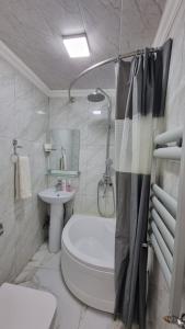 La salle de bains blanche est pourvue de toilettes et d'un lavabo. dans l'établissement Sam Rental 1, à Samarcande