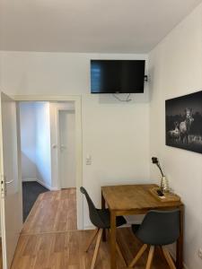 a dining room with a wooden table and a television on the wall at Apartment für 2 Personen in Wiesbaden