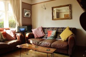 a living room with a couch and a mirror at Helene - Dog Friendly Family Home on Norfolk Coast in Potter Heigham