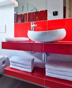 baño con lavabo blanco y armarios rojos en BIESZCZADZKI RAJ Luksusowe domki nad jeziorem 608-280-713, en Olchowiec