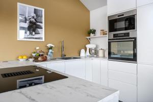 eine Küche mit weißen Schränken und einem Herd mit Backofen in der Unterkunft Familieresort i Bavallen in Skulestadmo + 15 Fotos