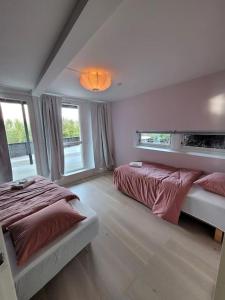 ein Schlafzimmer mit zwei Betten und zwei Fenstern in der Unterkunft Familieresort i Bavallen in Skulestadmo