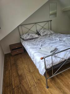ein Bett mit einem Metallrahmen und einem Holzboden in der Unterkunft Vakantiehuis Zuiderveld in Geesbrug