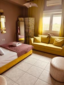 een slaapkamer met een bed, een bank en een raam bij Villa Oneiropagida in Preveza