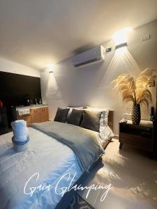 聖拉斐爾的住宿－Gaia Glamping Elegancia Escarlata estándar 1，一间卧室设有一张大床和一棵棕榈树