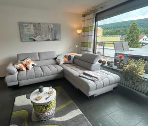 een woonkamer met een bank en een tafel bij Penthouse ,,Kleine Auszeit" in Bad Harzburg