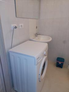 ein Badezimmer mit einer Waschmaschine und einem Waschbecken in der Unterkunft Casa Rizza in Portopalo