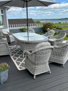 a table and chairs on a deck with an umbrella at Seacrest in Galway