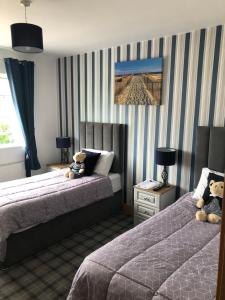 two beds in a hotel room with two teddy bears at Seacrest B&B in Galway