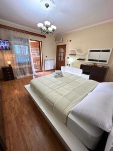 a large white bed in a room with a kitchen at Guest House Pulake in Berat