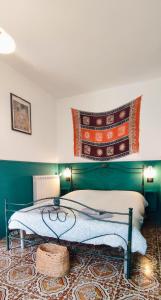 um quarto com uma cama com uma cabeceira verde em Tana Libera Tutti 1 Nature, Yourself, Love em Viggianello
