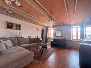 BIAMICI - casa de vacanze in Mombercelli في Mombercelli: غرفة معيشة مع أريكة وتلفزيون