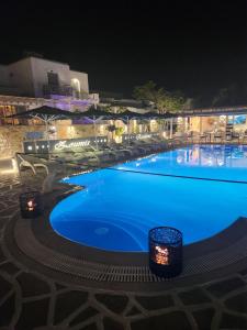 a large swimming pool with blue water at night at Zoumis Residence in Naousa