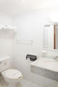 a white bathroom with a toilet and a sink at Hotel del Paseo Campeche in Campeche