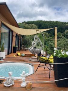 a patio with a hammock and a chair and a pool at Cuibul din livadă in Suduleni