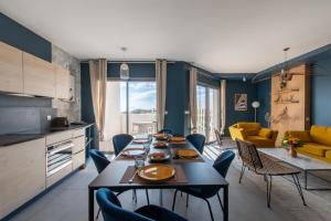 a kitchen and living room with a table and chairs at Luxury Mind Vue Exceptionnelle Pied dans l'eau Parkings privés 2 places Climatisation Hyper centre logement d'exception in La Grande-Motte +61 photos