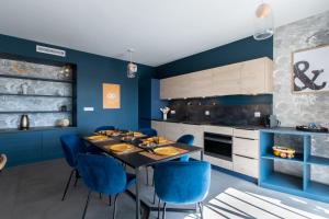 拉格朗德默特的住宿－Luxury Mind Vue Exceptionnelle Pied dans l'eau Parkings privés 2 places Climatisation Hyper centre logement d'exception，厨房拥有蓝色的墙壁,配有一张带蓝色椅子的桌子。