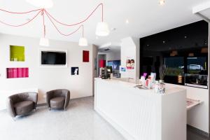 ein Friseursalon mit zwei Stühlen und einer Theke in der Unterkunft The Originals City, Marne-la-Vallée Est, Meaux ,GLASSY HOTEL in Meaux + 15 Fotos
