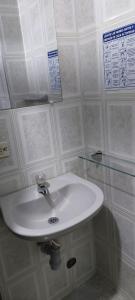 索加莫索hotel S & C的浴室里的一个白色水槽,墙上有标志 更多29张照片