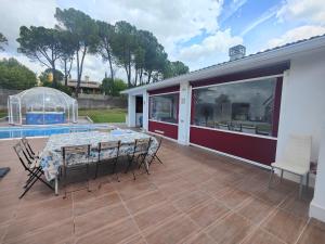 a patio with a table and chairs and a pool at habitaciones en Chalet con piscina y jacuzzi en Madrid in Algete
