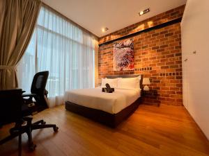 um quarto com uma cama e uma parede de tijolos em Soho Suites KLCC by Alucard's Cat em Kuala Lumpur