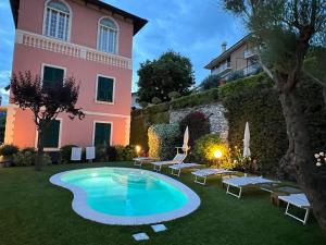 une villa avec une piscine en face d'un bâtiment dans l'établissement "Villa degli Ulivi" Wonderful Villa with private pool and sea view, à Recco