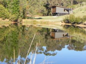 a reflection of a house in a lake at Queenstown Retreat B&B in Smith Gully Road