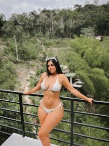 een vrouw in bikini die op een leuning staat bij Gaia Glamping Elegancia Escarlata estándar 1 in San Rafael