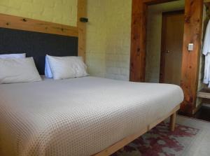 a bedroom with a large bed with white sheets at Queenstown Retreat B&B in Smith Gully Road