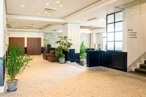 a lobby with potted plants in a building at Miyajima Coral Hotel in Miyajima