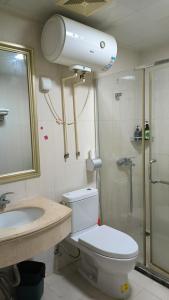 uma casa de banho com um WC, um chuveiro e um lavatório. em 广州朴宿漫享公寓(琶洲国际会展中心店） em Guangzhou