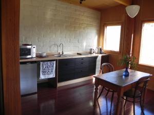 a kitchen with a sink and a table with a microwave at Queenstown Retreat B&B in Smith Gully Road