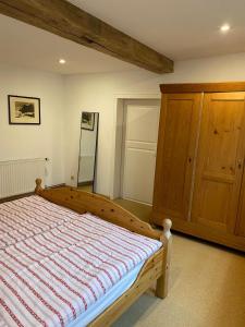 a bedroom with a bed and a wooden cabinet at Schloßbergwohnung Löwenhaus in Homberg