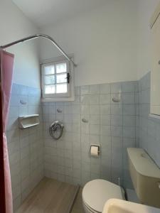 a bathroom with a toilet and a window at Alexandra's Apartments in Sidari