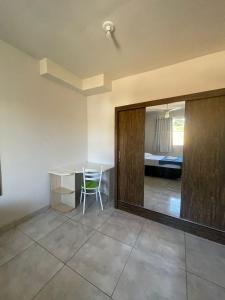 a room with a table and a chair and a bedroom at Flat centro in Ubá