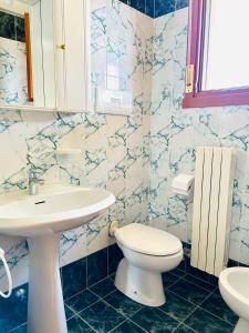 a bathroom with a white sink and a toilet at Beachside Family Garden Retreat in Cavallino-Treporti