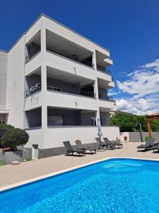 een huis met een zwembad voor een gebouw bij Villa Apartment AA 2 in Trogir