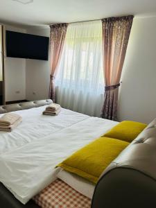 a bedroom with a large white bed with yellow pillows at Casa Victoria in Gura Hangului +50 photos
