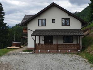 a small white house with a driveway in front at Cabana belvedere (VIS) in Colibiţa