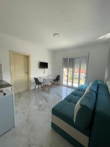 a living room with a blue couch and a table at Noara Apartments Modern Stay Near Beach Free Parking Ideal for Families and Groups in Donji Štoj