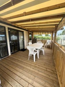 une terrasse en bois avec une table et des chaises. dans l'établissement Camping le Moulin de la Salle, à Les Sables-dʼOlonne