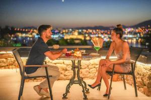 a man and woman sitting at a table with a drink at Manastir Hotel & Suites in Bodrum City