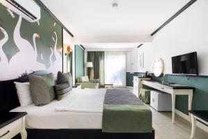 Habitación de hotel con cama grande y TV en Manastir Hotel & Suites, en Bodrum City